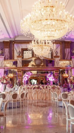 A chandelier-lit ballroom set for a wedding reception